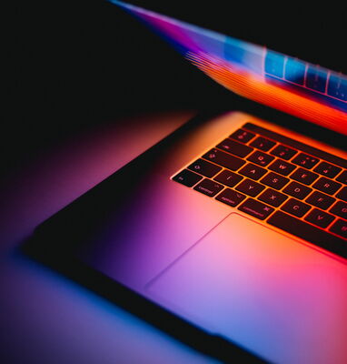 Laptop mit leuchtendem Bildschirm im Dunklen